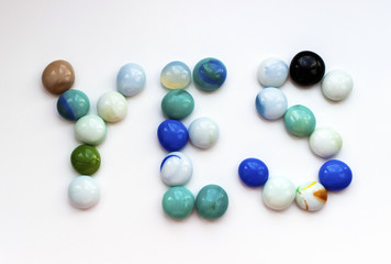 The word YES is laid out in English by colored stones