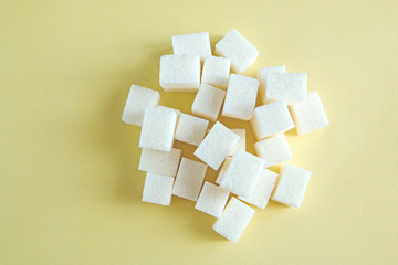 white refined sugar randomly spread out on a yellow background