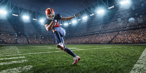 Fototapeta na wymiar American football player performs an action play on professional sport stadium