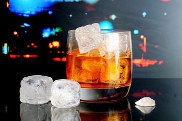 Glass of whiskey. City background.
