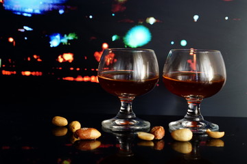Two galass of cognac, city lights background.