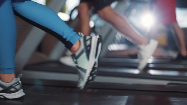 Close up view of running foots on treadmill machine in gym shoes girl sport fitness athletic body active cardio equipment physical run woman fit health legs workout exercise healthy