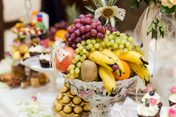 fruit on a plate such as bananas and grapes, kiwi, orange