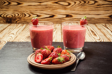 healthy strawberry yogurt with fresh berries on old wooden background