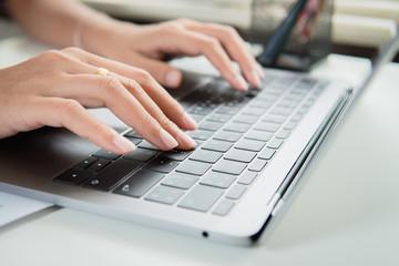 Close up woman working at home office hand on laptop.
