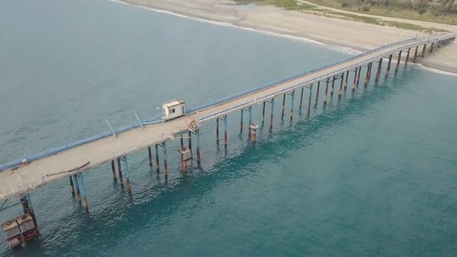 Pontile in mare con tubi per cemento e ormeggi per l'attracco delle navi