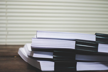 Stack of business report paper file on wooden table.
