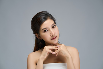 Happy beautiful asian girl with the fresh skin in white background. Expressive facial expressions. Cosmetology and Spa concept.