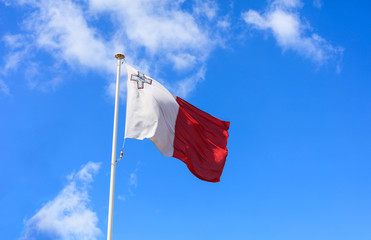 Malta flag. Malta flag on a pole waving on blue sky background