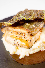Sturgeon, savoy cabbage, mushrooms broth, mashed potato with butter on a plate on a white background