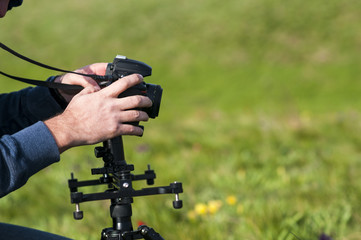 Young male photographer taking photo by DSLR camera. Nature and landscape photography