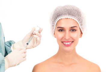 Aging facial treatment concept. Doctor injecting botox to beautiful young woman isolated on white background.