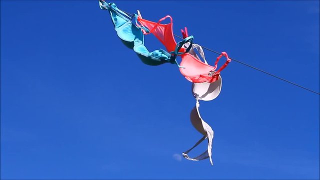Woman's bras drying on a washing line on a sunny windy day 