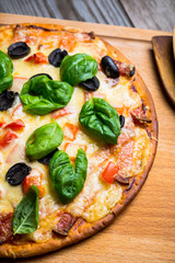 Fresh pizza served on wooden table. Selective focus.