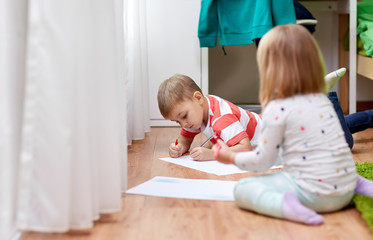 childhood, leisure and people concept - happy boy drawing at home