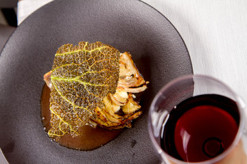 Sturgeon, savoy cabbage, mushrooms broth, mashed potato with butter served in a restaurant