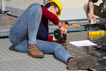 young engineer girl and an elderly skilled worker fitting a photovoltaic plant