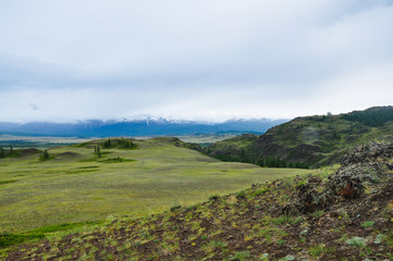 Fototapeta na wymiar Altai mountains landscape. The mountain range behind the steppe and hills