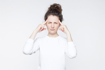 Frustrated attractive woman has terrible headache keeping hands on temples frowning face with pain looking unhappy and stressful. Housewife suffering in despair having stressful situation in life.