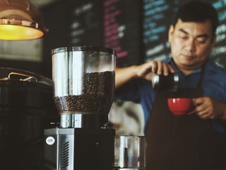 Asian man making a coffee in cafe.