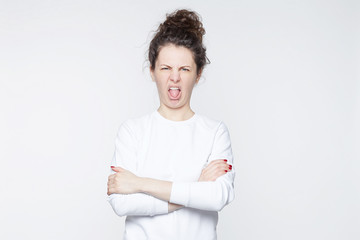 Funny Caucasian woman closes eyes and opens mouth with tongue, sees something sour, isolated over...