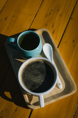 Black coffee in a white cup on the wooden table.