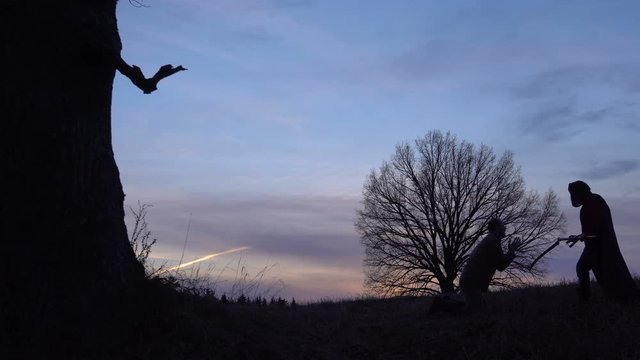 Grim Reaper came for a new victim and leads the victim to death. And the man begs for mercy. sunset silhouette. concept of death and the struggle for life