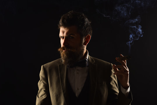 Business and bad habit concept. Man with beard holds cigar