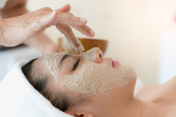 Naklejka premium Young asian women treatment with facial mask in spa beauty salon.