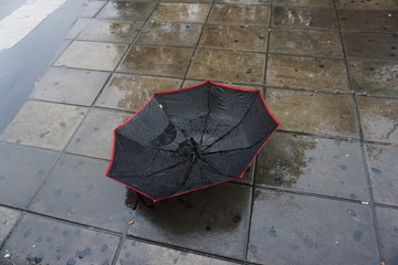 Primer plano de un paraguas roto en la calle. 