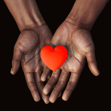 African hands holding a red heart