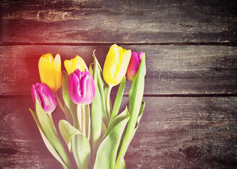 Tulip flowers on aged wooden background.