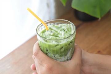 Iced macha or matcha green tea milk in tall glass.