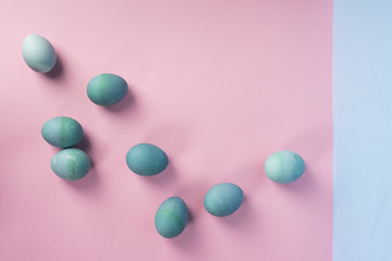 Several different shades blue eggs on the geometric pink and blue background.