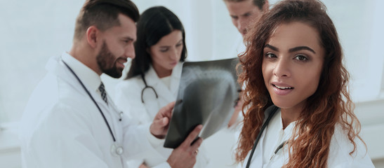 confident doctors in hospital looking at x-ray.