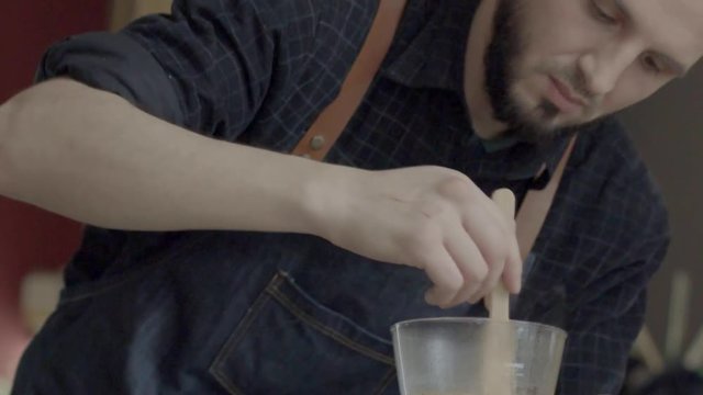 A young Caucasian barista man prepare coffee Syphon Stir