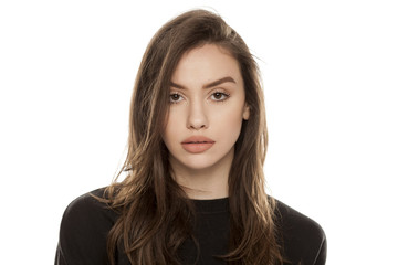 Portrait of beautiful young woman looking in camera on white background