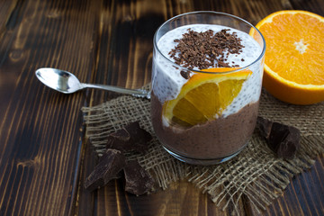 Chocolate pudding with chia and orange on the rustic wooden background