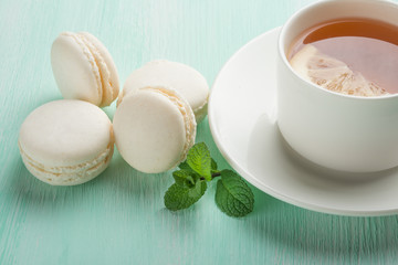 Tea with mint and lemon and white macaroons with mint