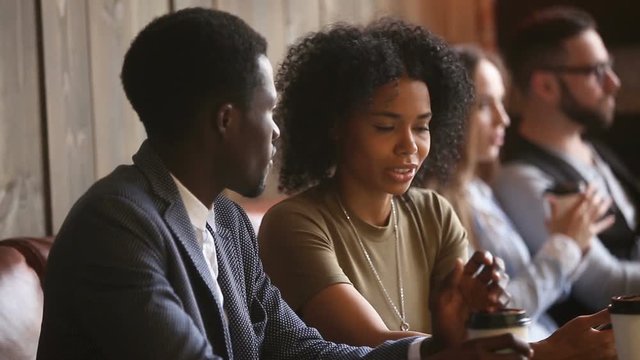 African american young couple talking sitting at cafe table during lunch break, black man and woman having pleasant conversation on date in coffeehouse, dark-skinned friends discuss news in coffeeshop