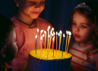 Children's birthday. Children near a birthday cake with candles.