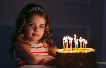 Birthday. A little sweet girl blows out candles on the stoke.