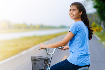 Girl with bike, Woman riding a bicycle on road in a park