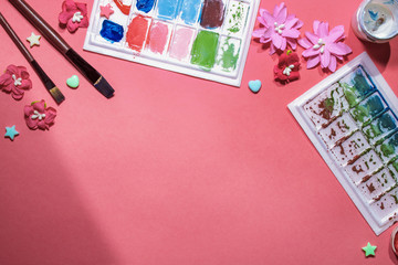 Color gouache jars on pink background. Top view, copy space