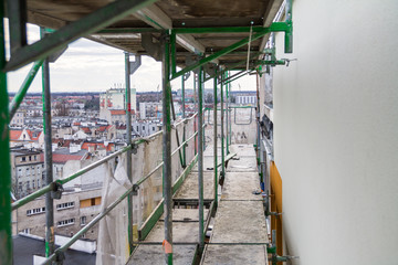 Fototapeta na wymiar Home repairs, scaffolding, updating the façade of the house renovations