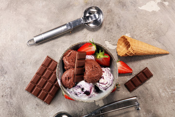 Chocolate coffee ice cream ball in a bowl and strawberry and vanilla