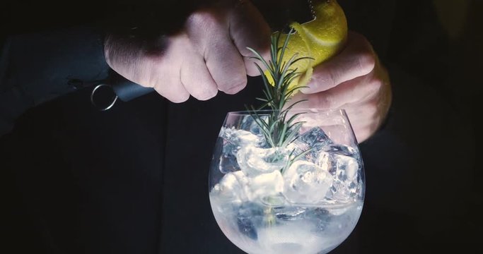 in a nightclub or pub, a professional bartender preparing a cocktail with ice a mix of alcohol. The barman measure quantities for a perfect cocktail. concept: disco, fun, friends, cocktail.