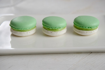 White-green macaroons on a white plate