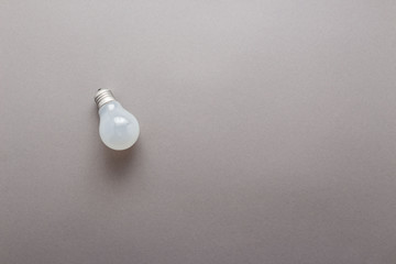 Light bulb on grey background top view, flat lay with copy space