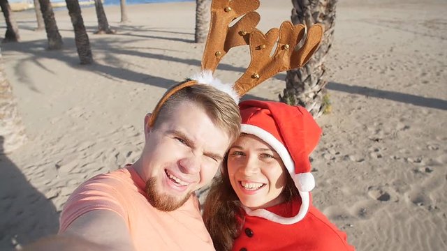 Happy Christmas couple selfie picture on beach vacation